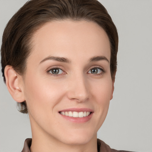 Joyful white young-adult female with short  brown hair and grey eyes