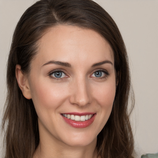 Joyful white young-adult female with long  brown hair and grey eyes