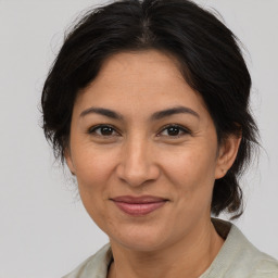 Joyful latino adult female with medium  brown hair and brown eyes