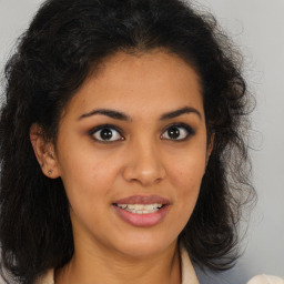 Joyful latino young-adult female with long  brown hair and brown eyes