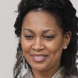 Joyful black adult female with long  brown hair and brown eyes