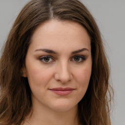 Joyful white young-adult female with long  brown hair and green eyes