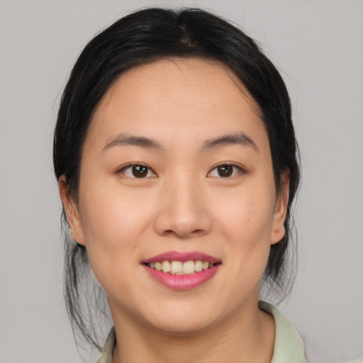 Joyful asian young-adult female with medium  black hair and brown eyes