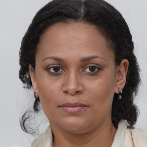Joyful black adult female with medium  brown hair and brown eyes