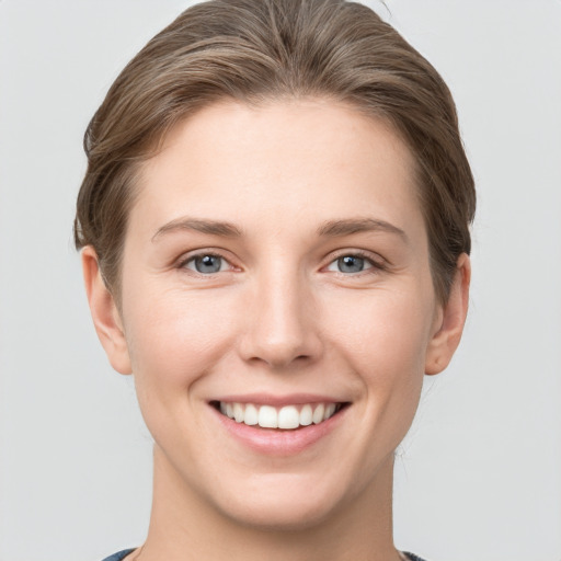 Joyful white young-adult female with short  brown hair and grey eyes