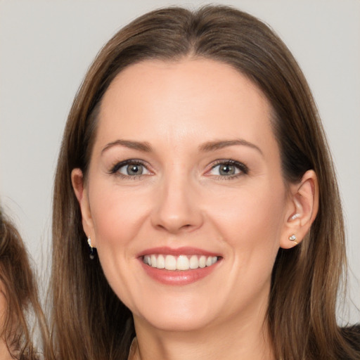 Joyful white young-adult female with long  brown hair and brown eyes