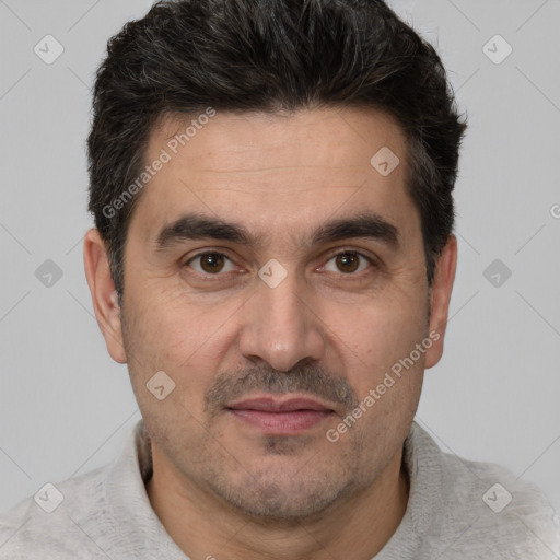 Joyful white adult male with short  black hair and brown eyes