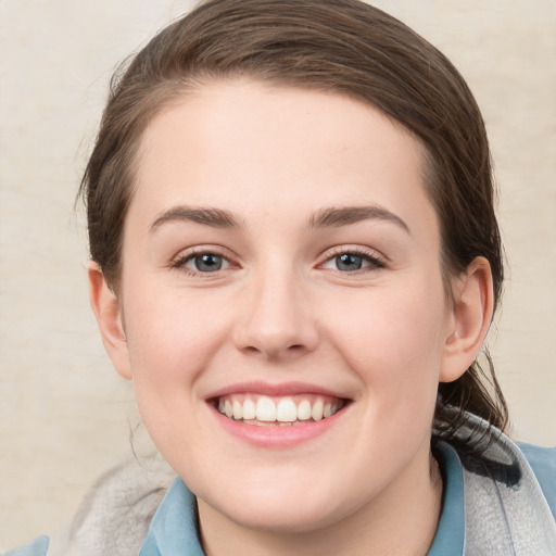 Joyful white young-adult female with medium  brown hair and blue eyes