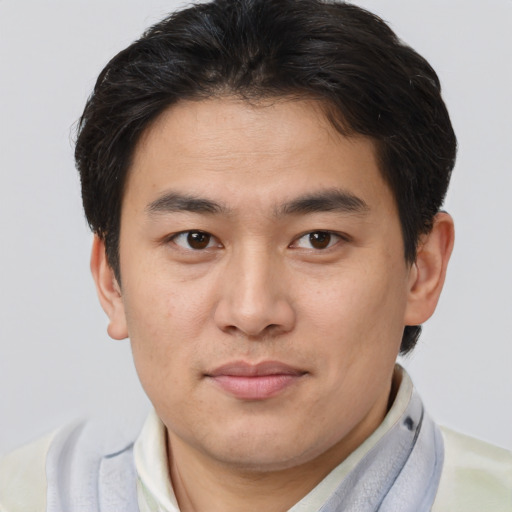 Joyful asian young-adult male with short  brown hair and brown eyes