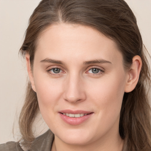 Joyful white young-adult female with long  brown hair and grey eyes