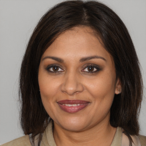 Joyful black adult female with medium  brown hair and brown eyes