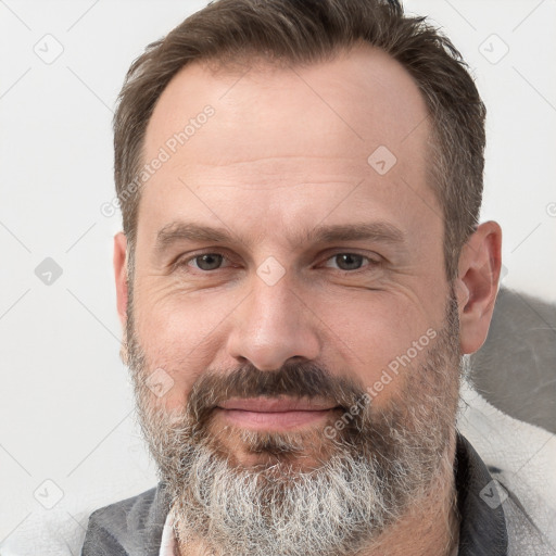 Joyful white adult male with short  brown hair and grey eyes