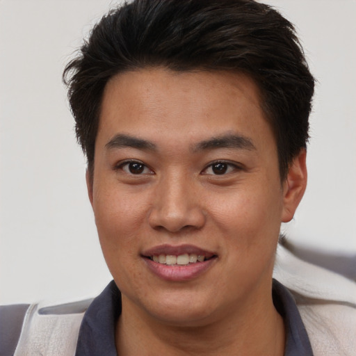 Joyful asian young-adult male with short  brown hair and brown eyes