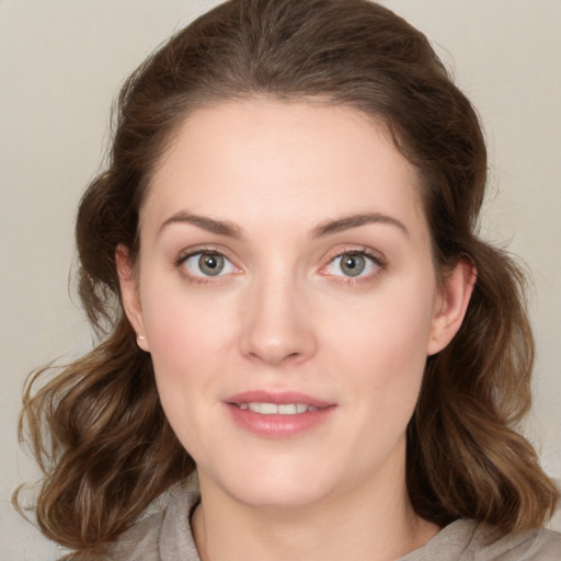 Joyful white young-adult female with medium  brown hair and green eyes