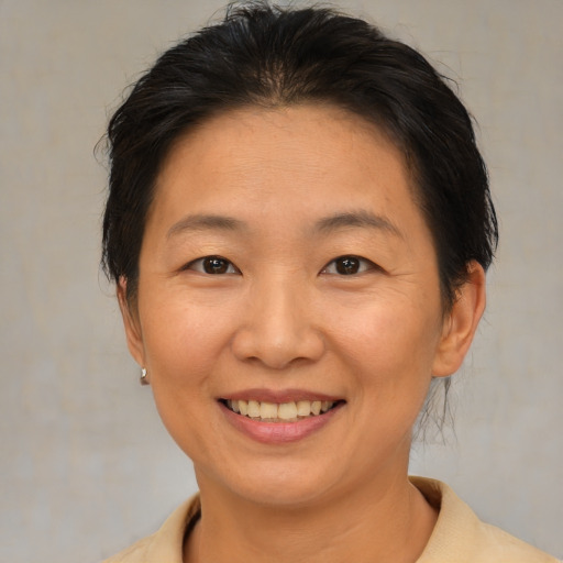 Joyful asian adult female with medium  brown hair and brown eyes