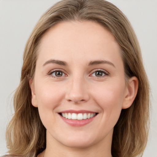 Joyful white young-adult female with long  brown hair and grey eyes