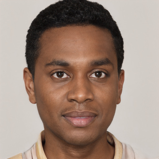 Joyful black young-adult male with short  black hair and brown eyes