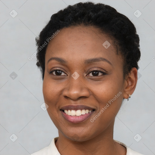 Joyful black young-adult female with short  black hair and brown eyes