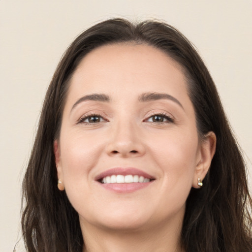 Joyful white young-adult female with long  brown hair and brown eyes