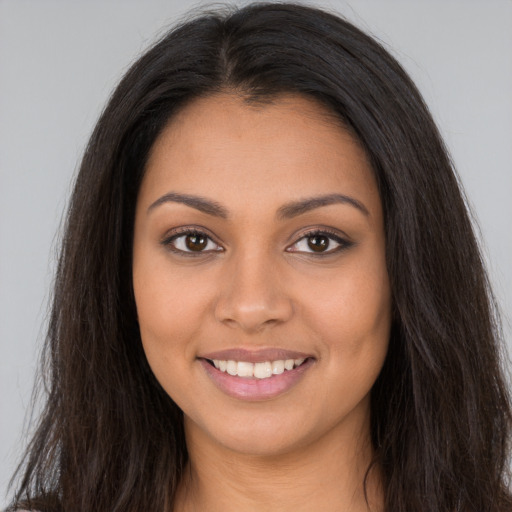 Joyful latino young-adult female with long  brown hair and brown eyes