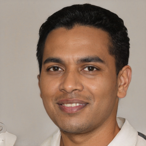 Joyful black young-adult male with short  black hair and brown eyes