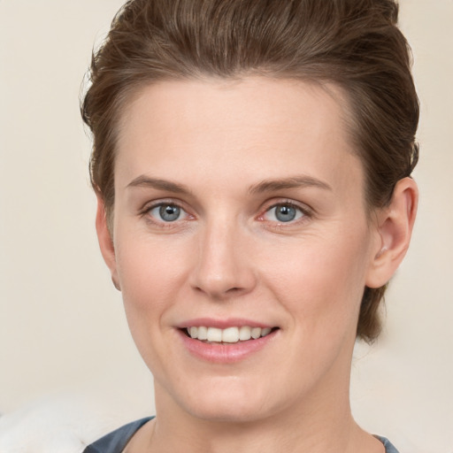 Joyful white young-adult female with short  brown hair and grey eyes