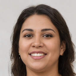 Joyful latino young-adult female with long  brown hair and brown eyes