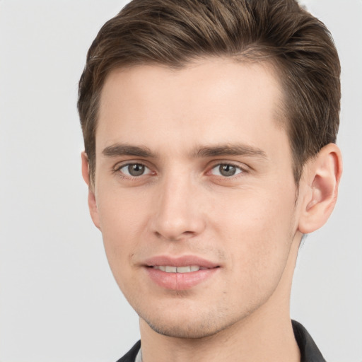 Joyful white young-adult male with short  brown hair and grey eyes