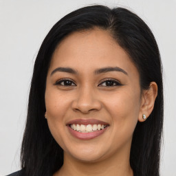 Joyful latino young-adult female with long  brown hair and brown eyes