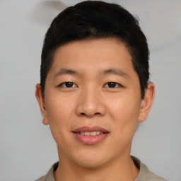 Joyful asian young-adult male with short  brown hair and brown eyes