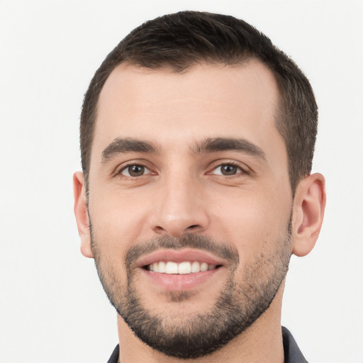 Joyful white young-adult male with short  black hair and brown eyes