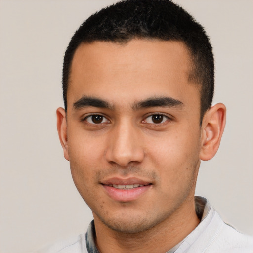 Joyful latino young-adult male with short  brown hair and brown eyes