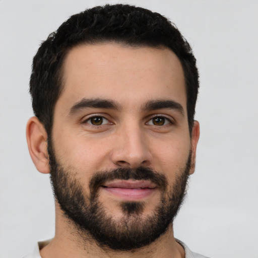 Joyful latino young-adult male with short  black hair and brown eyes