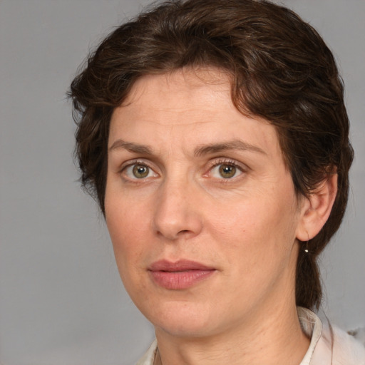 Joyful white adult female with medium  brown hair and green eyes