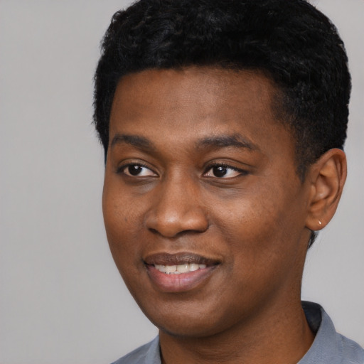 Joyful black young-adult male with short  black hair and brown eyes