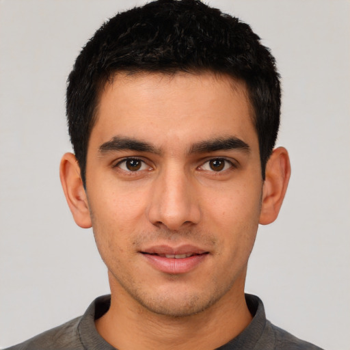 Joyful white young-adult male with short  black hair and brown eyes