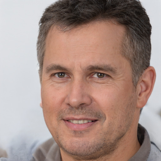 Joyful white adult male with short  brown hair and brown eyes