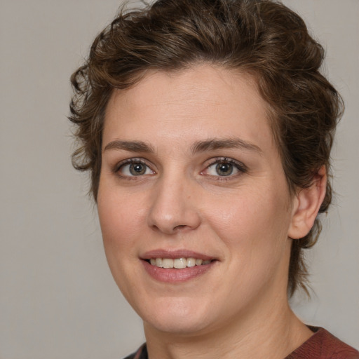 Joyful white young-adult female with medium  brown hair and green eyes