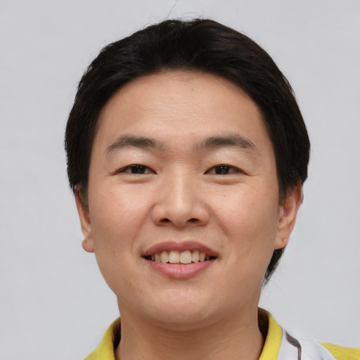 Joyful asian young-adult male with short  brown hair and brown eyes