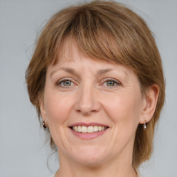 Joyful white adult female with medium  brown hair and grey eyes