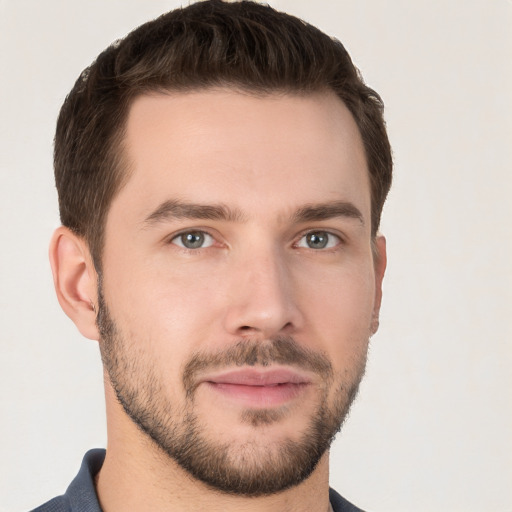 Joyful white young-adult male with short  brown hair and grey eyes