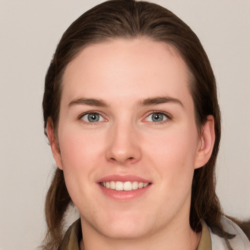 Joyful white young-adult female with medium  brown hair and grey eyes