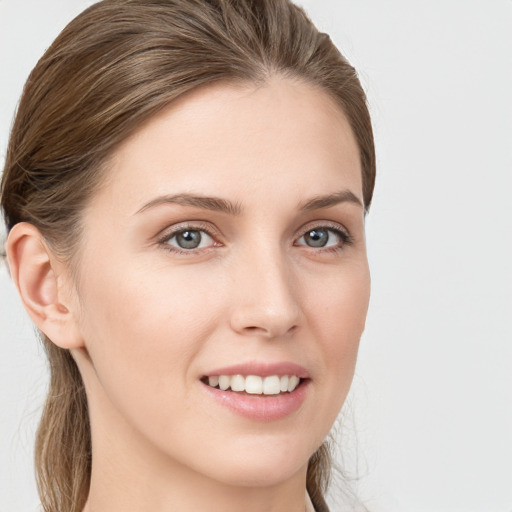 Joyful white young-adult female with medium  brown hair and grey eyes