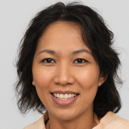 Joyful asian adult female with medium  brown hair and brown eyes