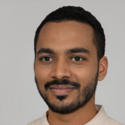 Joyful black young-adult male with short  black hair and brown eyes