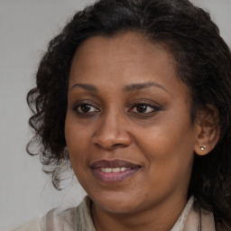 Joyful black adult female with long  brown hair and brown eyes