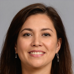 Joyful white adult female with long  brown hair and brown eyes