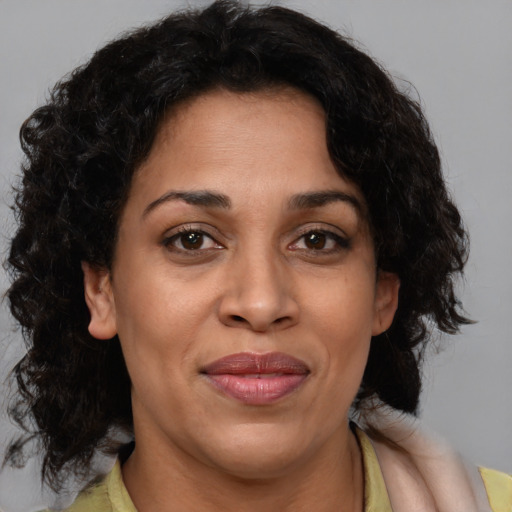 Joyful latino adult female with medium  brown hair and brown eyes
