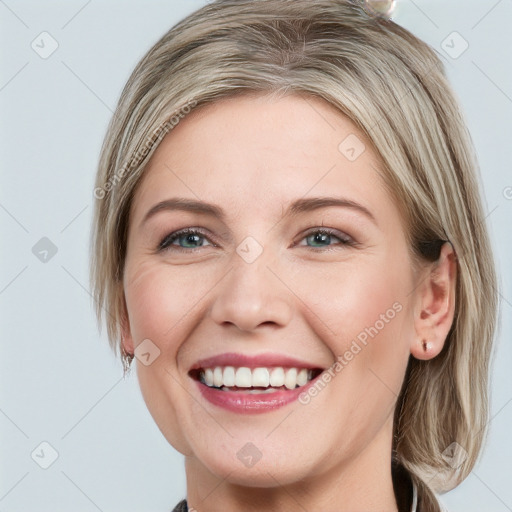 Joyful white young-adult female with medium  brown hair and blue eyes