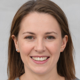 Joyful white young-adult female with long  brown hair and grey eyes